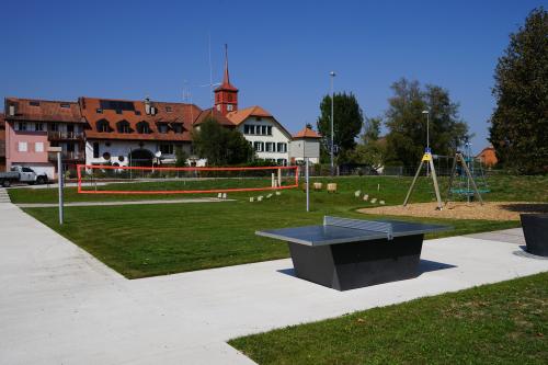 Espace recréatif avec terrain de volleyball et table de ping-pong