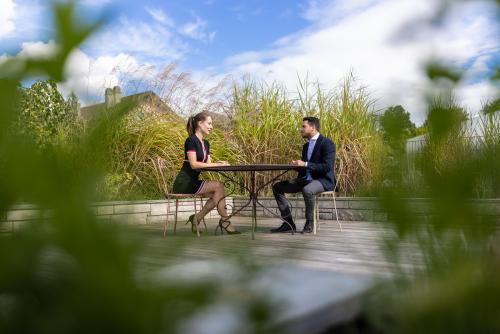 Personnes qui discute à une table sur une terrasse de jardin