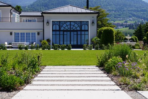 Chemin en dalles passe-pied traversant un jardin bien entretenu