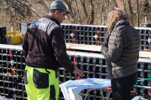 Direction des travaux et chef paysagiste qui discutent sur un plan