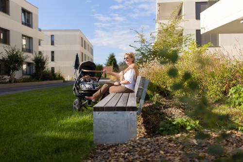 Banc urbain et maman assise avec une poussette